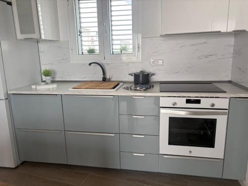 a white kitchen with a stove and a sink at Casa Caladero in El Golfo