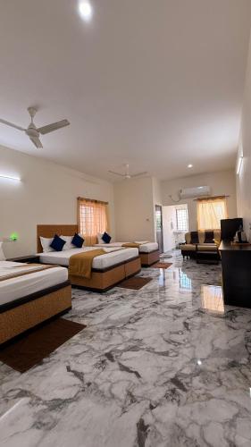 a large room with two beds and couches in it at DSS HOME STAY Just 500 Meter Girivalam Road in Tiruvannāmalai