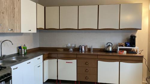 a kitchen with white cabinets and a counter top at yellow house in Verrès