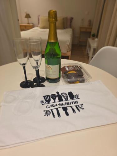 a bottle of wine and two glasses on a table at Casa Martins in Porto