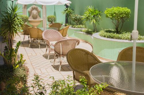 a patio with chairs and tables and an umbrella at L'Opera Hotel in Sao Paulo