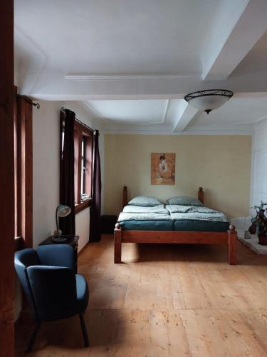 a bedroom with a bed and a chair in it at Ferienwohnung Harald in Gotha