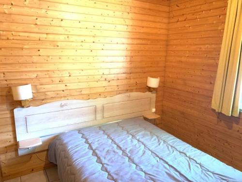 a bedroom with a bed in a wooden wall at ZEcamping 3 étoiles animaux acceptés piscine snack bar et restaurant in Moutiers-sous-Chantemerle