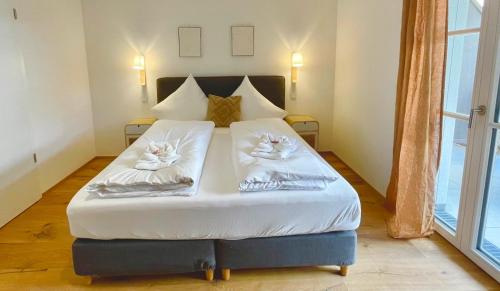 a bedroom with a bed with two cats on pillows at Ferienwohnung "Traumsuite am Tegernsee" in Tegernsee