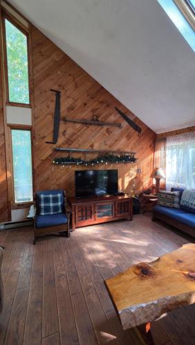 un soggiorno con un divano e una TV di Cabin in the pines a Tamworth