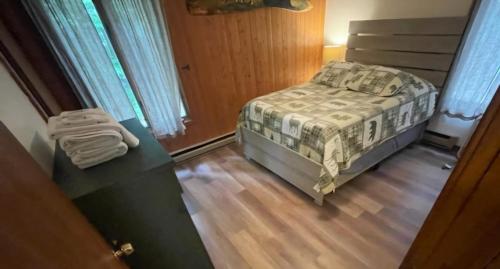 una camera da letto con un letto e un pavimento in legno di Cabin in the pines a Tamworth