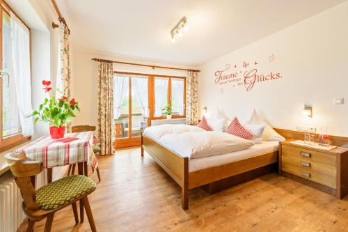 a bedroom with a bed and a table and a chair at Haus Aigner in Fischen