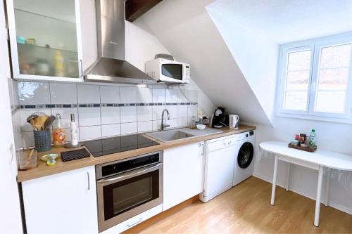 a white kitchen with a sink and a stove at Gîte cosy et paisible près de La Mongie in Campan