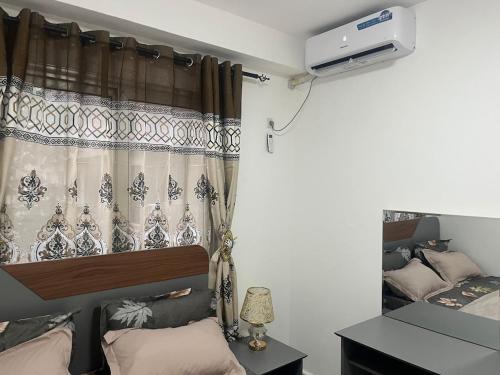a bedroom with a bed and a window with a curtain at At your home in Conakry in Conakry