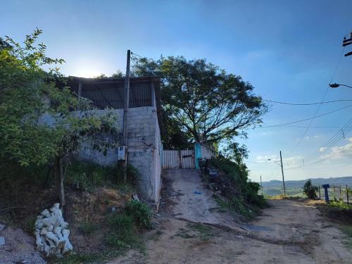 un chemin de terre à côté d'un bâtiment blanc dans l'établissement CHÁCARA dos CHEIROS, à Atibaia
