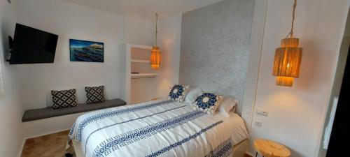 a bedroom with a bed with blue and white sheets at Hôtel Riad La Nouvelle Etoile - Agadir in Agadir