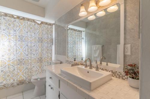 een badkamer met een wastafel, een toilet en een spiegel bij Legoland Escape in Winter Haven