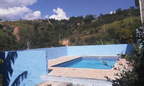 - une piscine sur le côté d'un bâtiment bleu dans l'établissement CHÁCARA dos CHEIROS, à Atibaia