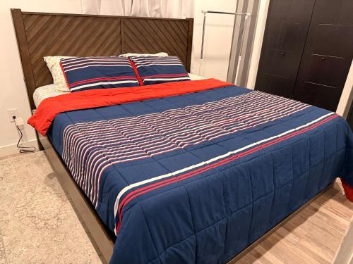 ein Bett mit einer blauen und roten Decke und Kissen in der Unterkunft Home away from home in Winnipeg