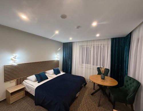 una camera da letto con un letto, un tavolo e una sedia di Simona House a Šiauliai