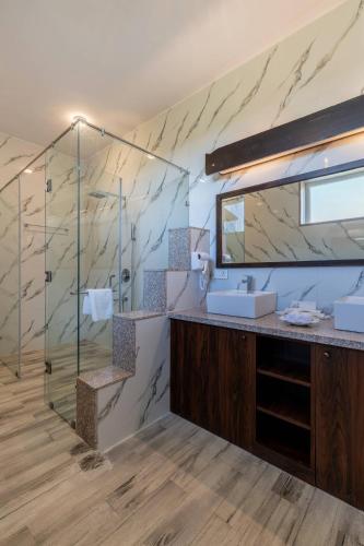 a bathroom with a glass shower and a sink at juSTa Luxe Highpoint Jawai in Bijāpur