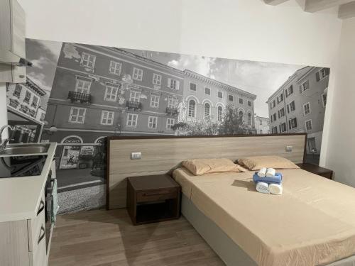 a bedroom with a bed with a painting on the wall at ROCKEFELLER SUIT Apartment in Sassari