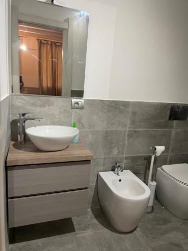 a bathroom with a sink and a toilet and a mirror at ROCKEFELLER SUIT Apartment in Sassari