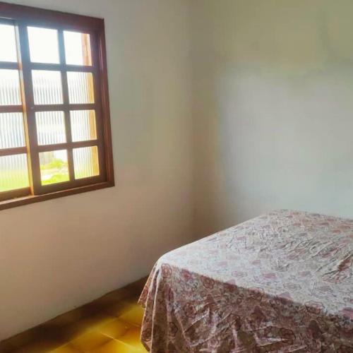 a bedroom with a bed and a window at Casa para até 6 pessoas, próxima do mar in Cidreira