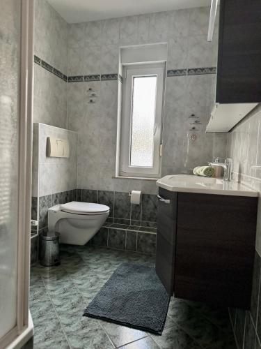 a bathroom with a toilet and a sink and a tub at Ferienhaus Heideblick Gräfenhainichen in Gräfenhainichen