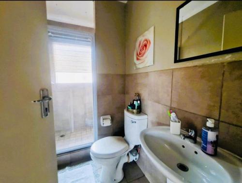 a bathroom with a toilet and a tub and a sink at Blissfulnest stay two in Roodepoort