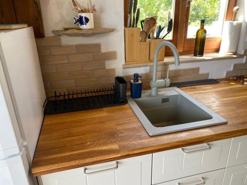 a kitchen counter with a sink and a window at Girica in Ugrinići
