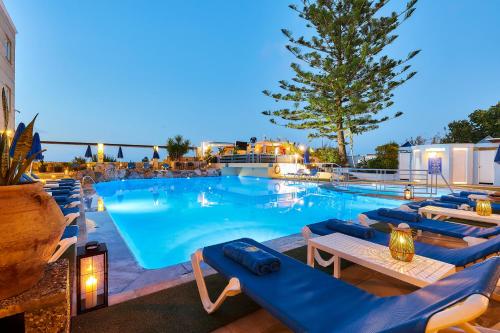 a large swimming pool with blue lounge chairs at Futura Hotel in Maleme