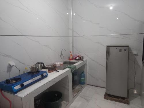 a small kitchen with a sink and a refrigerator at Femi in Dakar