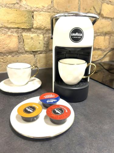 eine Kaffeemaschine mit zwei Tassen auf der Theke in der Unterkunft Green Bridge Studio in Vilnius