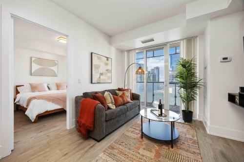 a living room with a couch and a bed at Condo by CN Tower & Rogers Centre in Toronto