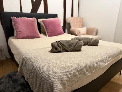 - une chambre avec un lit doté d'oreillers et d'une chaise dans l'établissement Le cocon chic, à Montereau-faut-Yonne