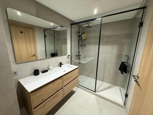 a bathroom with a sink and a glass shower at Hilton View Tower Residency Apartment Tanger Partial Sea View in Tangier