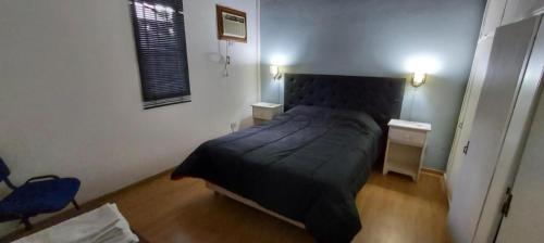 a bedroom with a black bed in a room at Merlo2 in Merlo