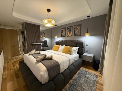 a bedroom with a large bed with a leather headboard at Hilton View Tower Residency Apartment Tanger Partial Sea View in Tangier