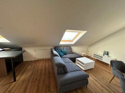 een woonkamer met een bank en een dakraam bij Ferienwohnung Waldzauber in Naumburg