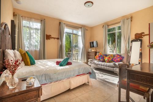 a bedroom with a bed and a couch and windows at Casa divertida ideal para grupos grandes con o sin niños in Tequisquiapan