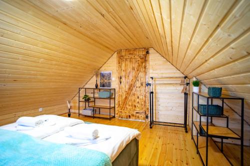 a bedroom with a bed in a room with a wooden ceiling at Ustronne Karkonosze in Miłków