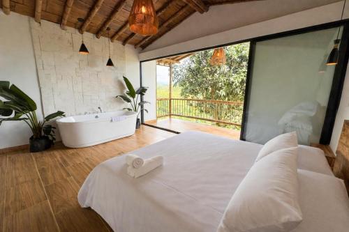菲兰迪亚Tukawa的一间卧室配有一张大床、一个浴缸和一个水槽