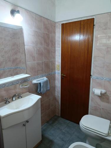 une salle de bains avec lavabo, toilettes et miroir dans l'établissement Casa en centro de Icho Cruz, à Villa Icho Cruz