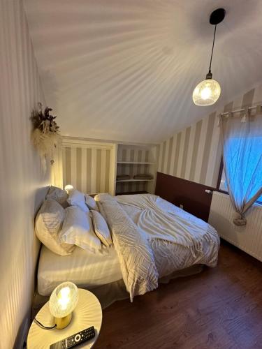 a bedroom with a large bed and a table at L'écrin du sancy in La Bourboule