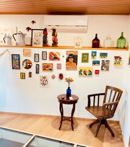 a room with a table and a chair and pictures on the wall at Casas Cor de Rosa in São Martinho das Moitas
