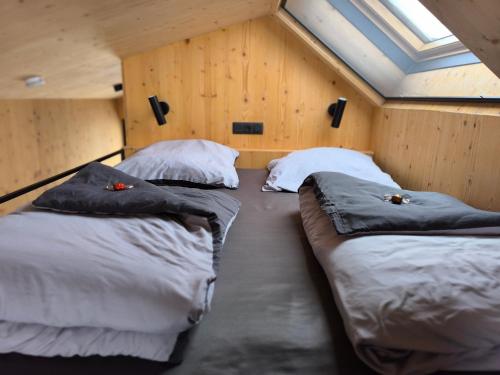 two beds in a room with wooden walls at Tiny House 1 im schönen Allgäu mit großem Garten, Naturnah in Bad Wurzach