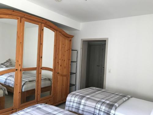 ein Schlafzimmer mit einem Holzschrank und einem Bett in der Unterkunft Villa Cologne - Apartments & Monteursquartiere in Meckenheim bei Köln in Meckenheim