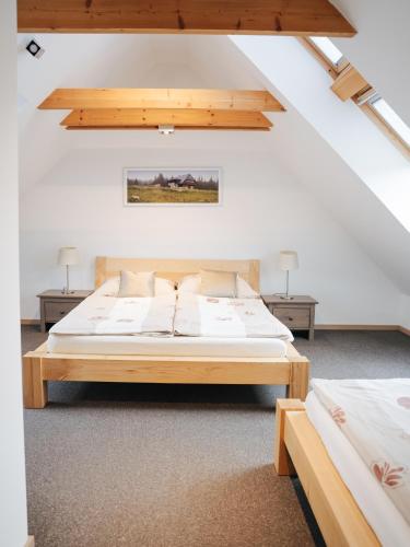 a bedroom with two beds in a attic at Apartmány Modrava in Modrava