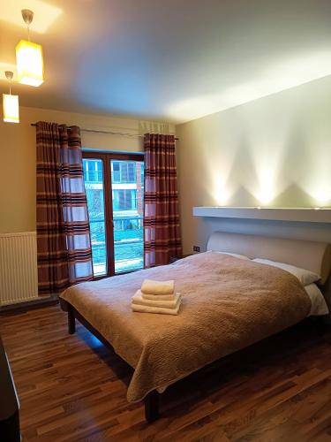 a bedroom with a bed with two towels on it at Apartament WENGE w centrum Ustronia in Ustroń