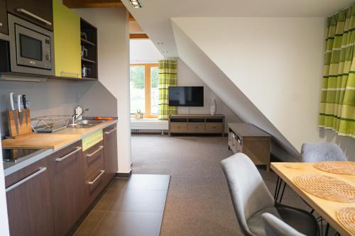 una cucina con un lavello e un tavolo con sedie di Apartmány Modrava a Modrava