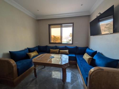un soggiorno con un divano blu e un tavolo di Appartement Calme Sidi Ifni a Sidi Ifni