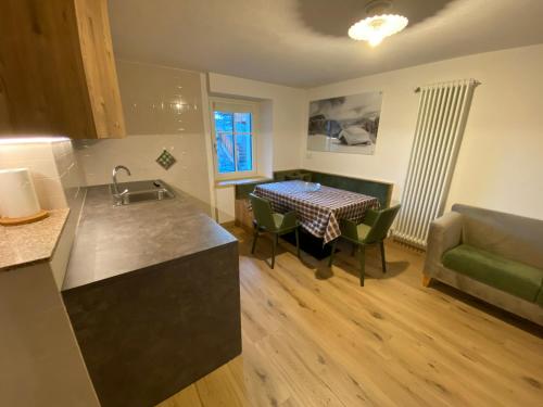 a kitchen and living room with a table and a couch at Casa Dorich in Pozza di Fassa