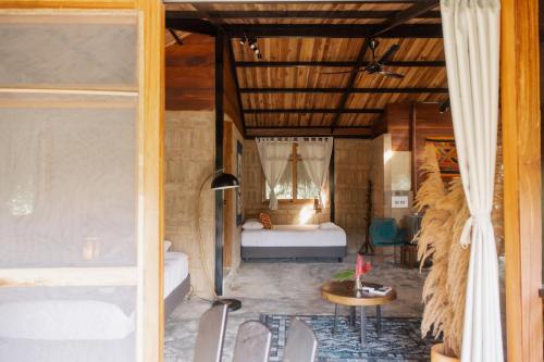 a room with a bedroom with a bed and a table at Salvia Madre Hotel Boutique in Guachaca