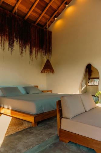 a bedroom with two beds and a couch at Pousada Buriti Atins Private in Atins